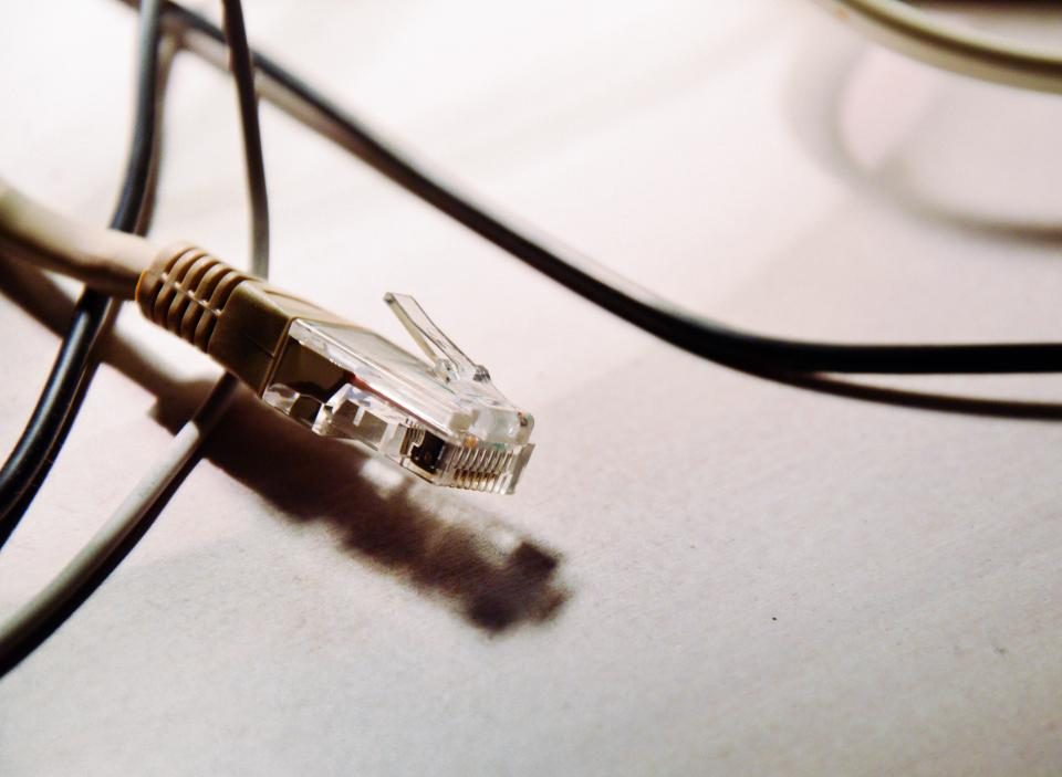 Et LAN-kabel med stik på en lys overflade